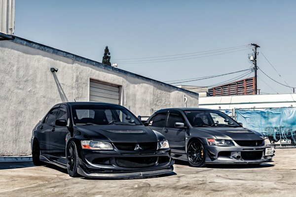 Two black mitsubishi lancer at the garage