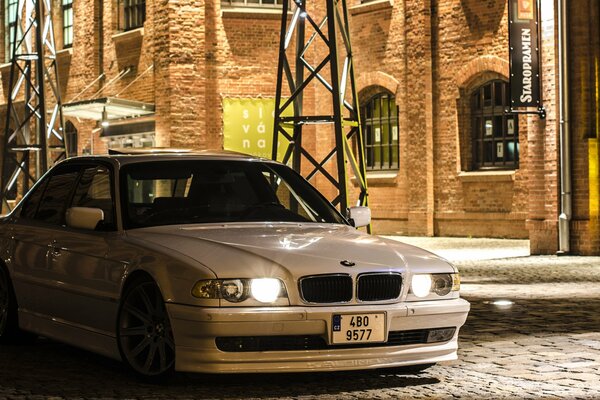 White bmw 740 on cobblestone pavement