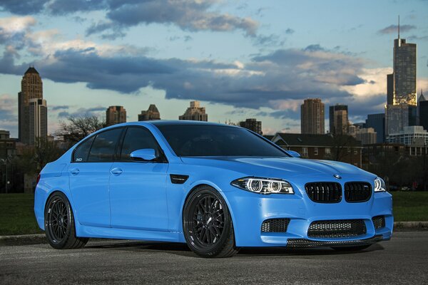 Blue bmw on the road against the backdrop of the metropolis