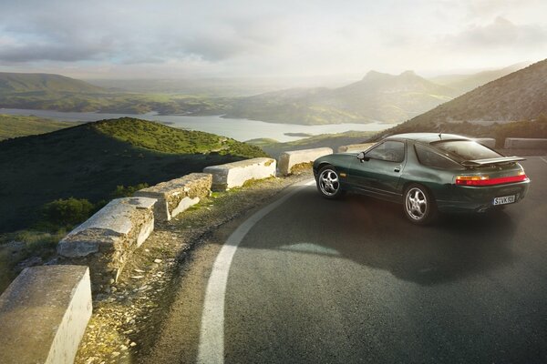 A 1991 Porsche gts stands at the edge of a mountain road