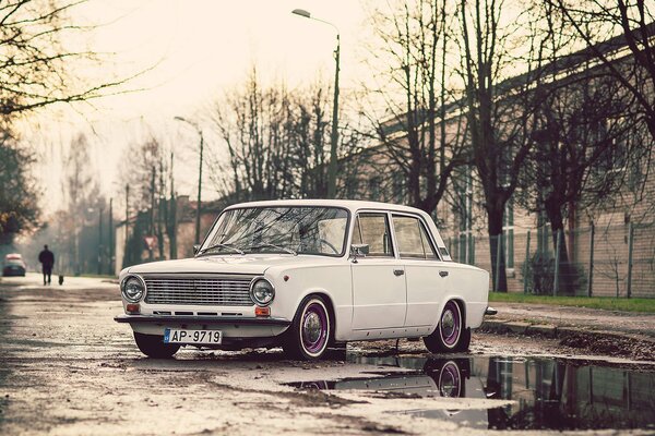 Lada Penny fährt langsam durch Herbstpfützen