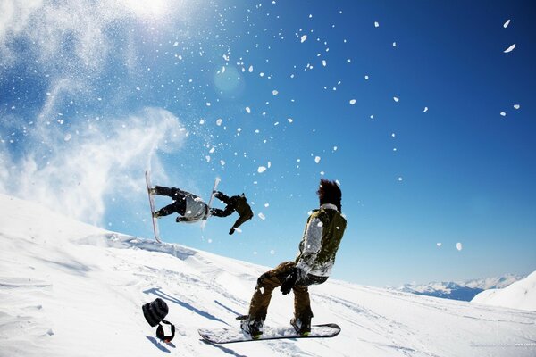 Snowboarder auf verschneiten Pisten machen Stunts