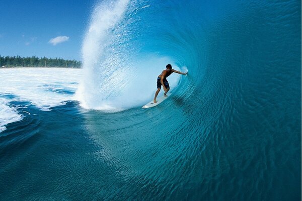 Surfer swims under the wave