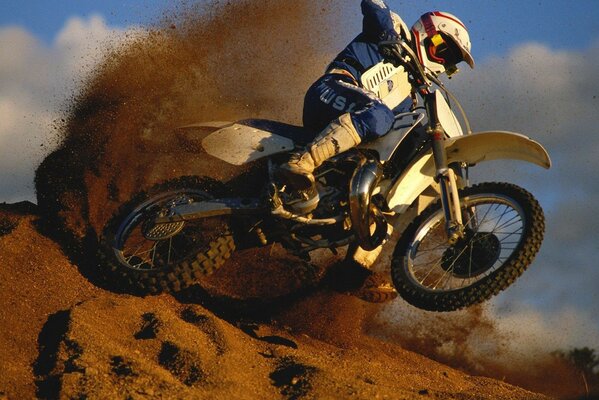 A biker is covered by a sand wave