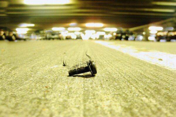 Ein rostiger schmutziger Bolzen liegt auf der Straße