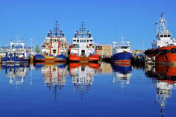 Ships are moored at the port of Australia, reflected in the water