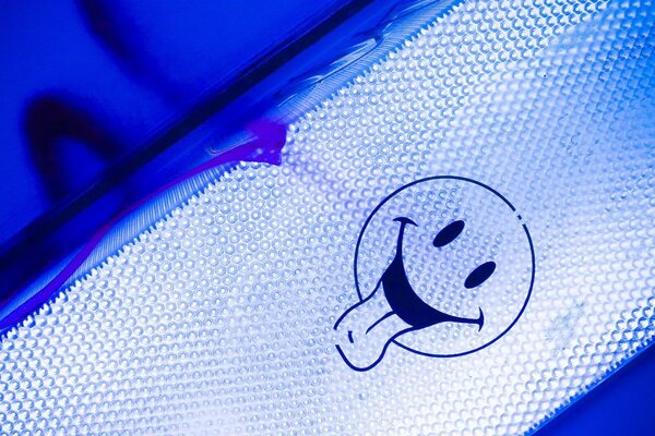 Image of a white smiley with a tongue on a blue background