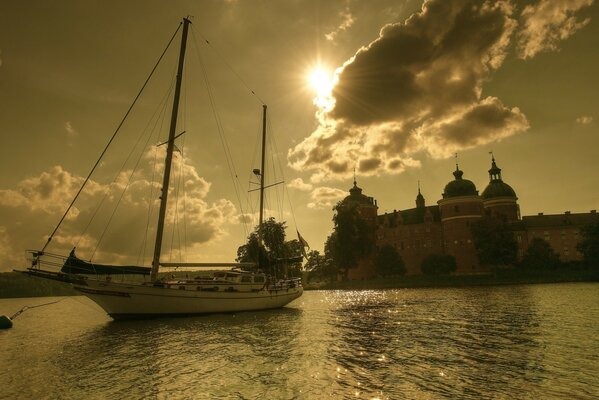 Yacht sullo sfondo del tramonto vicino al castello