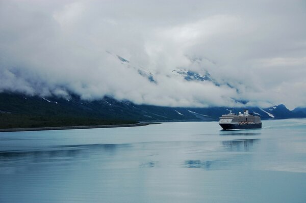 The ship sails on the sea against the background of thick clouds