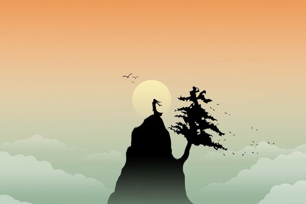 A man on a mountain with a tree against the sky