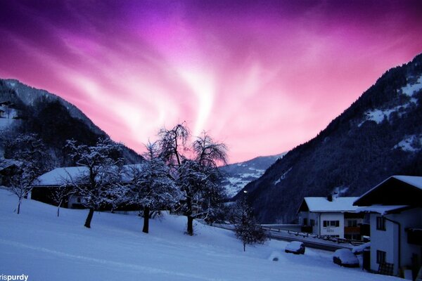 Aurora boreale in Alaska. Villaggio di montagna. Lilla cielo