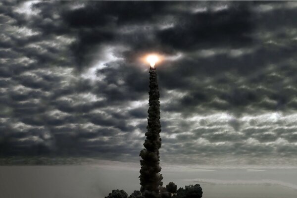 Ein leuchtendes orangefarbenes Leuchten auf der Spitze einer Steinsäule vor dem Hintergrund von Gewitterwolken