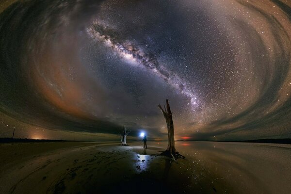 Un hombre con una linterna en el fondo de un resplandor Celestial