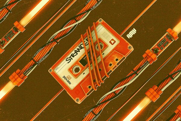 Orange compact cassette and wires on a brown background