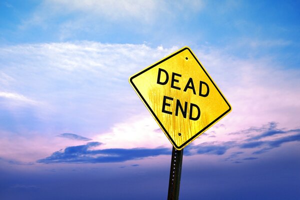 Yellow sign of a dead end against a cloudy blue sky