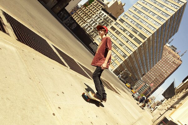 Ragazzo creativo su uno skateboard sul marciapiede