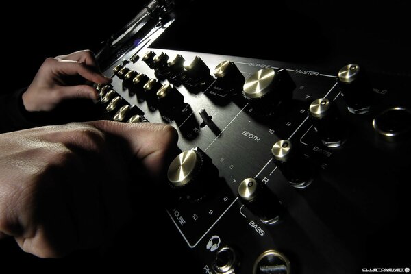 The fingers of a professional on a black amplifier