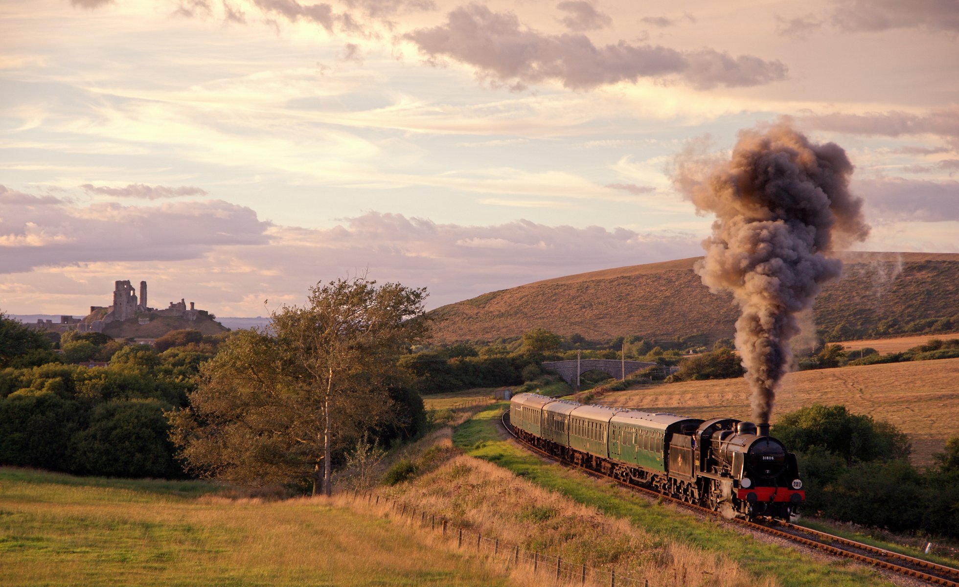 ferrocarril camino tren locomotora de vapor humo vagones prados campos terreno elevado ruinas del castillo de corfe reino unido