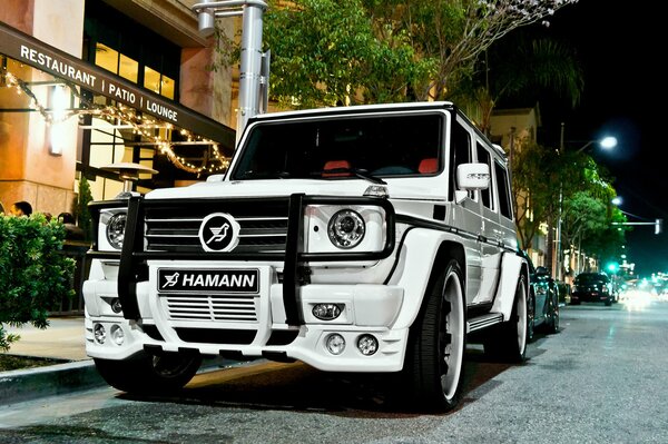 A white Mercedes parked at the buildings