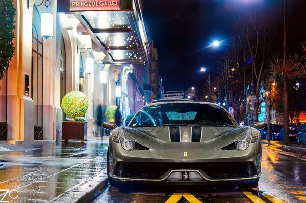 La strada di Parigi dopo la pioggia. Automobile di Ferrari sulla strada di notte