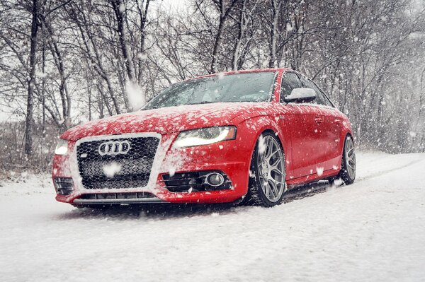 Audi rossa fresca sulla strada invernale