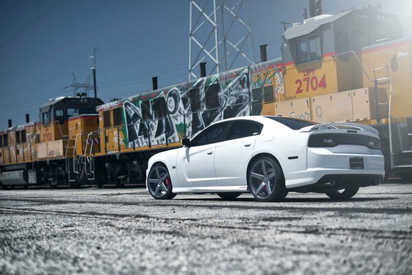 White Dodge on the background of an old train