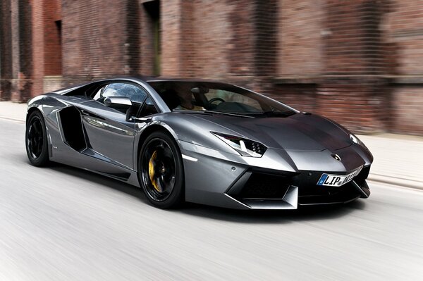 Silver Lamborghini on the background of a brick building