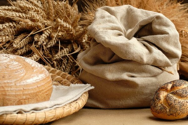 Brot mit einem Leinenbeutel auf einem Hintergrund von Ähren