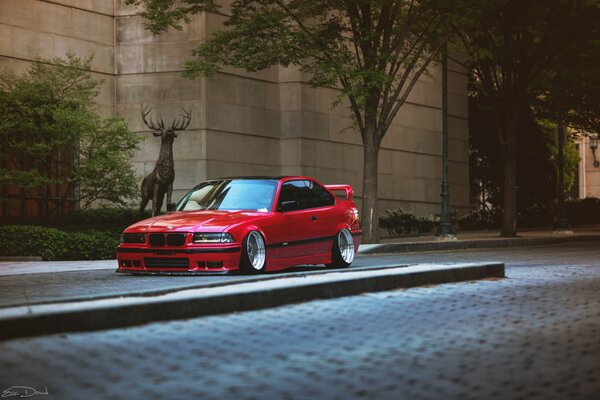 Bmw e36 red on the background of the building