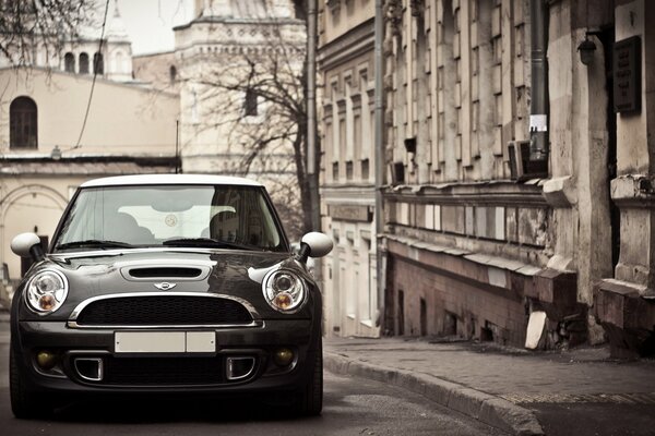 Mini Cooper en el fondo del paisaje de otoño