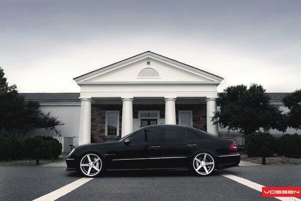 Mercedes benz negro en el fondo de una hermosa casa