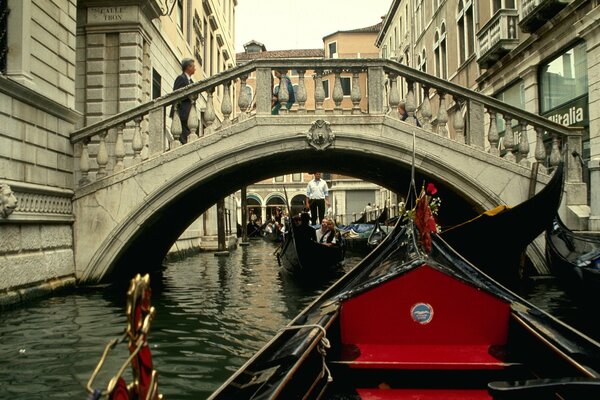 Gandola navega a través de un puente en Venecia