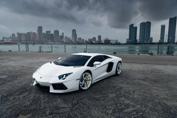 Lamborghini blanc sur fond de ville nuageuse