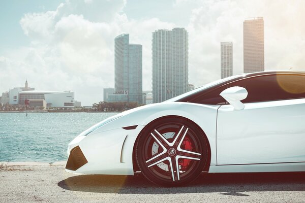 Lamborghini blanco contra el fondo del río y los rascacielos