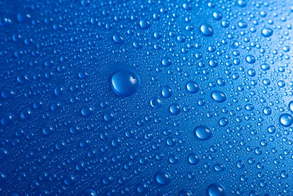 Blue background splattered with small and large transparent drops