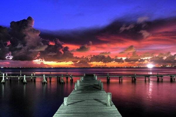 Beautiful bridge over the water on the background of sunset