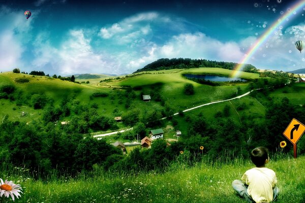 A little boy is sitting on the grass and looking at the sky