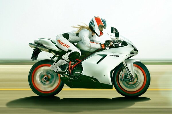 A rider in white on a Ducati motorcycle