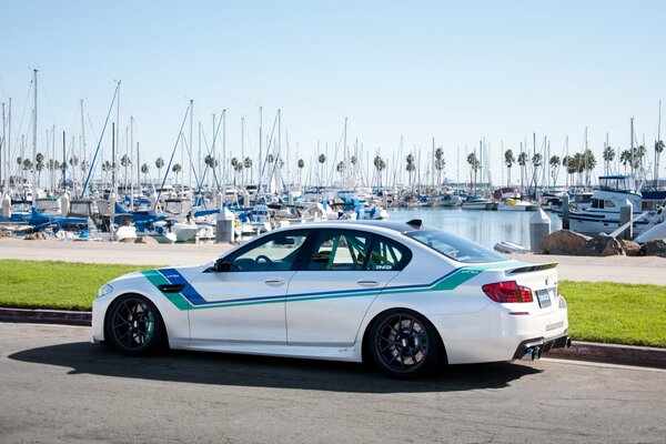 Coche deportivo bmw en el fondo del muelle con yates