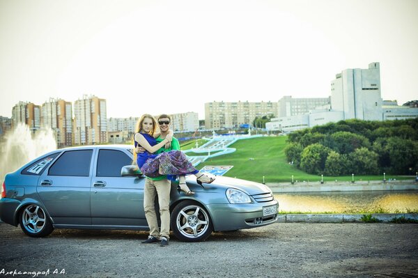 A guy holds a girl in his arms against the background of frets