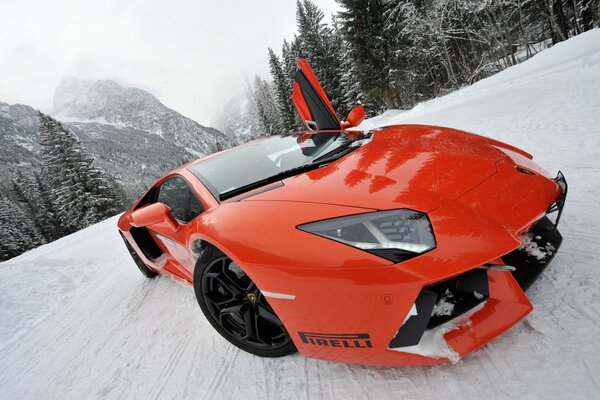 Lamborghini coral sports car in winter on a snowy road