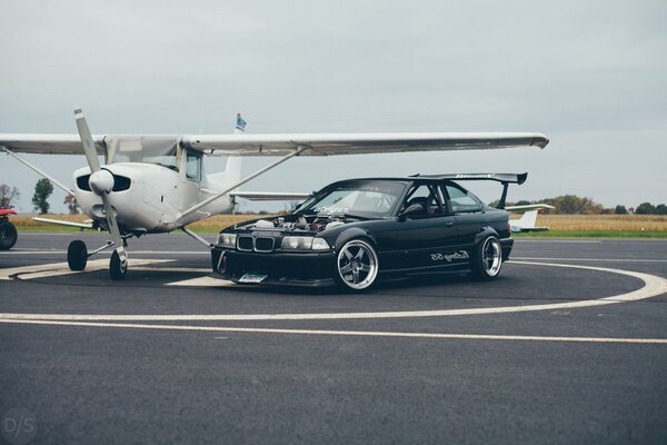 BMW car next to the plane on the take-off pad