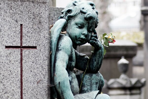 Engelskulptur mit Blume auf grauem Hintergrund