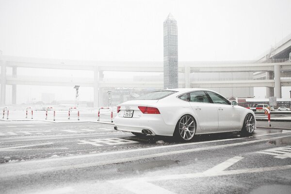 Une audi A7 blanche roule dans la neige