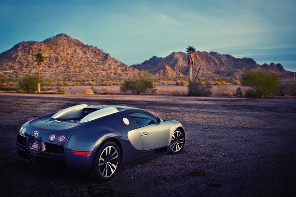 Bugatti in der Wüste vor dem Hintergrund der Berge im Abendlicht