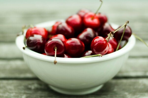 Tazón de cerezas en una mesa de madera