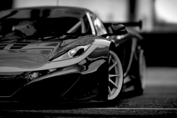 Black and white McLaren is standing on the road