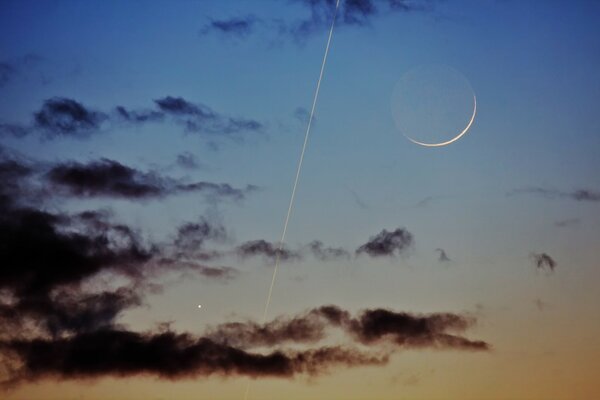 Dark clouds with a trail and a moon in the sky