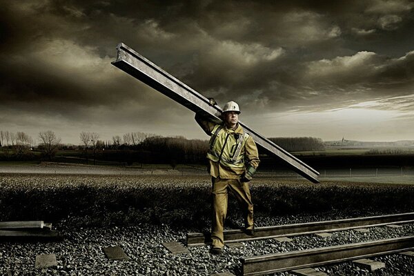 A worker with a rail on the railway