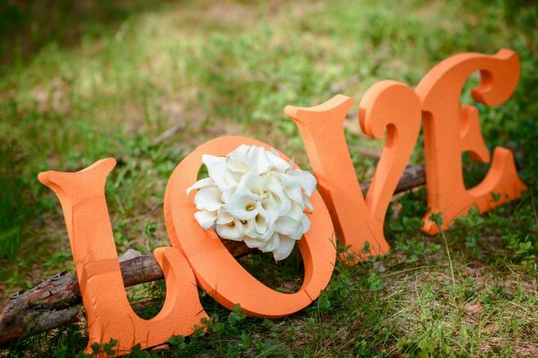 The inscription love with a white flower